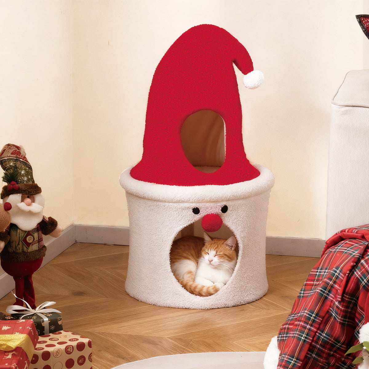 A cat sleeps inside the lower opening of the festive cat condo