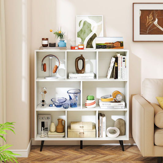 The white bookcase styled with decorative items and books in a living room