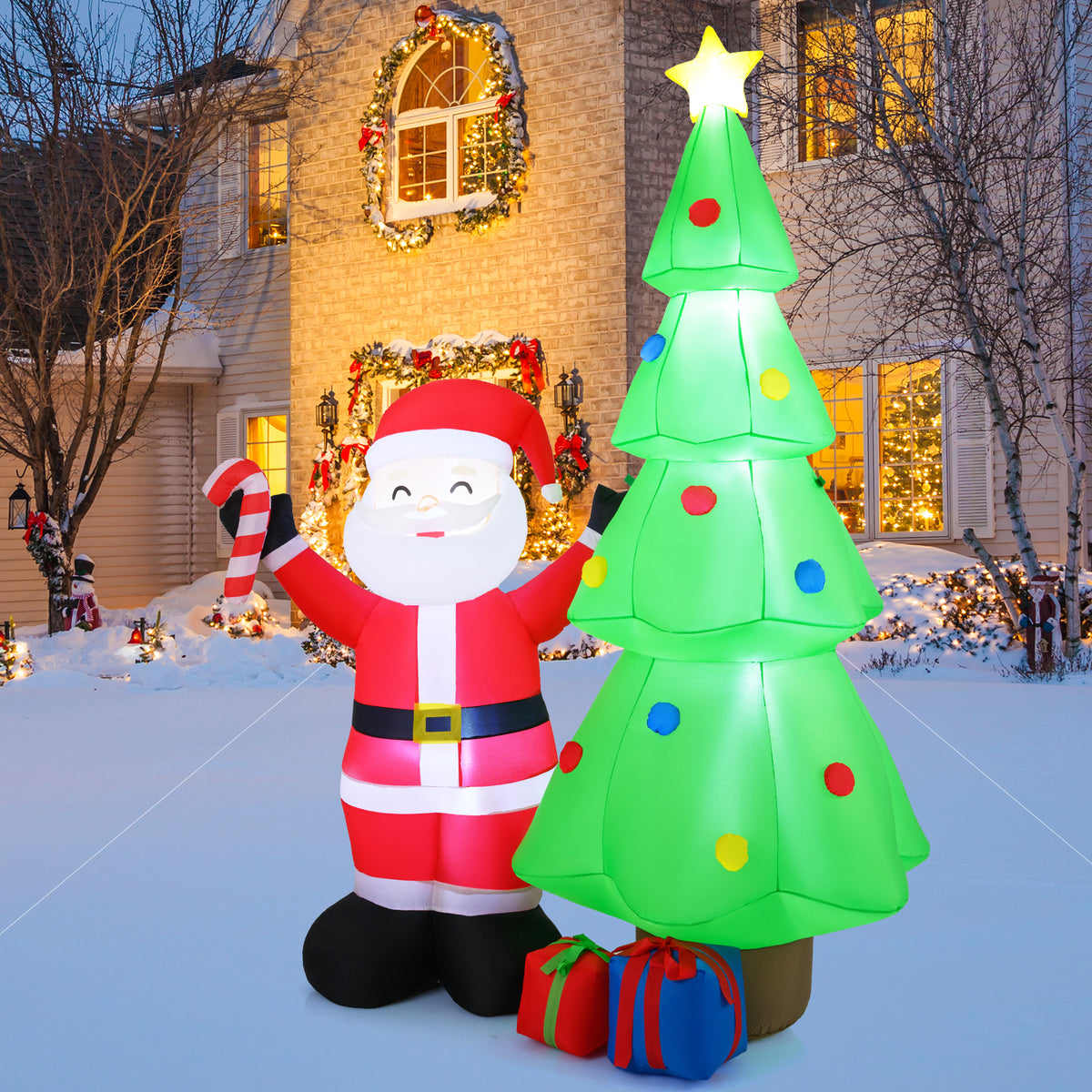 The inflatable Santa Claus and Christmas tree decoration is displayed in a garden setting at dusk
