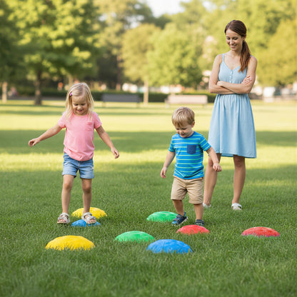 A woman supervises children playing with stepping stones on grass