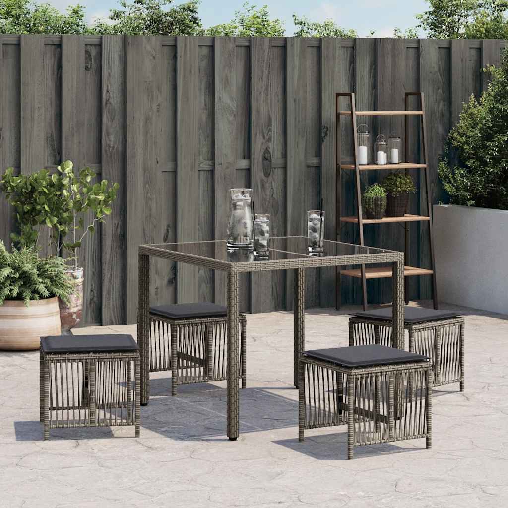 Four grey poly rattan garden stools with cushions arranged around a table on a patio