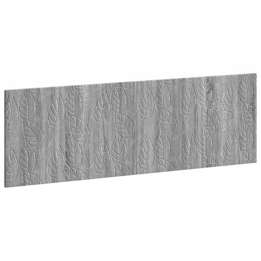 The headboard with a grey wood grain finish and a textured leaf pattern on the front surface