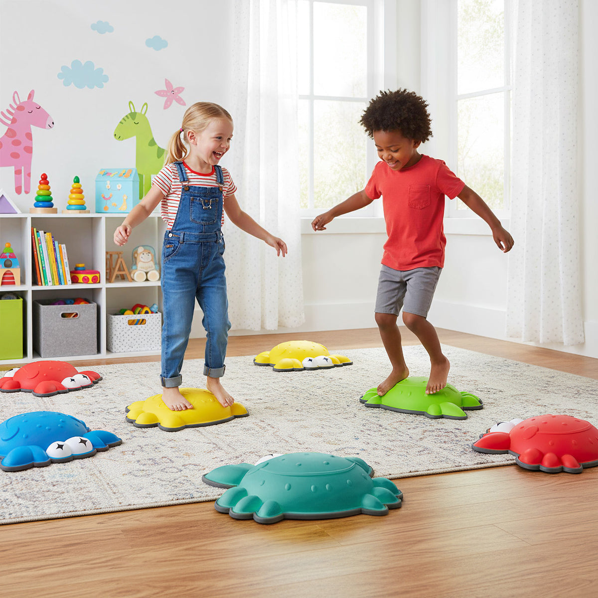 Children playing on the colourful crab stepping stones in a bright room