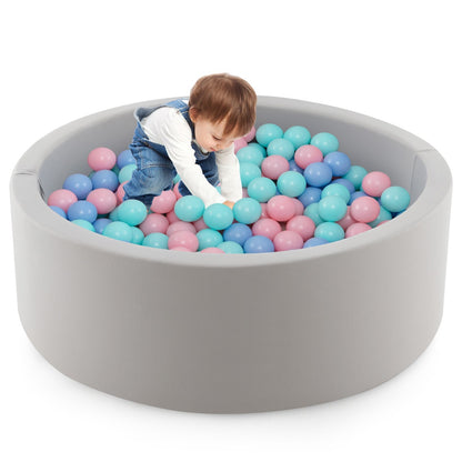 A toddler playing with the colourful balls inside the soft play set
