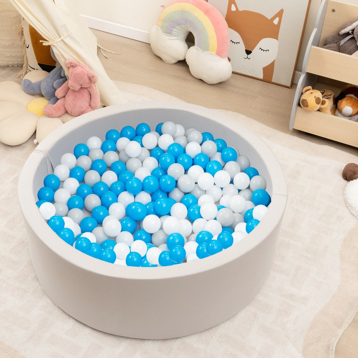 A toddler playing in the soft play set with blue, white and grey balls