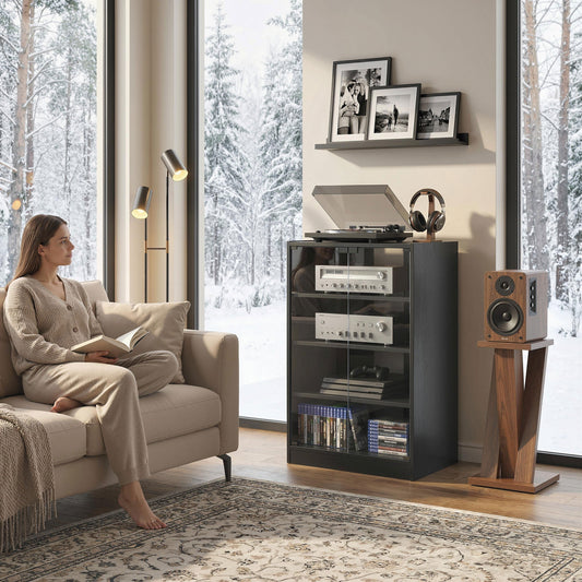 A woman reads a book on a sofa next to the hi-fi stand holding a record player and speaker in a living room