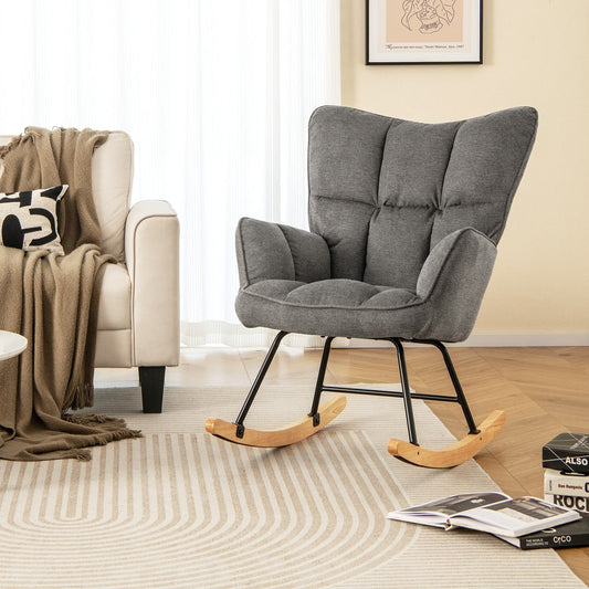 Grey fabric nursery rocking chair in a living room setting next to a sofa