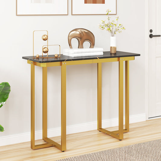 Grey faux marble console table with gold geometric legs in a hallway