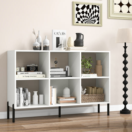 The white bookcase styled with books and ornaments in a living room next to a tall floor lamp