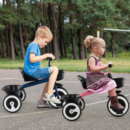 Two children, a boy and a girl, ride the navy and pink push and pedal ride on toys outdoors