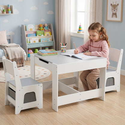A young girl sitting at the kids table and chair set drawing in a notebook