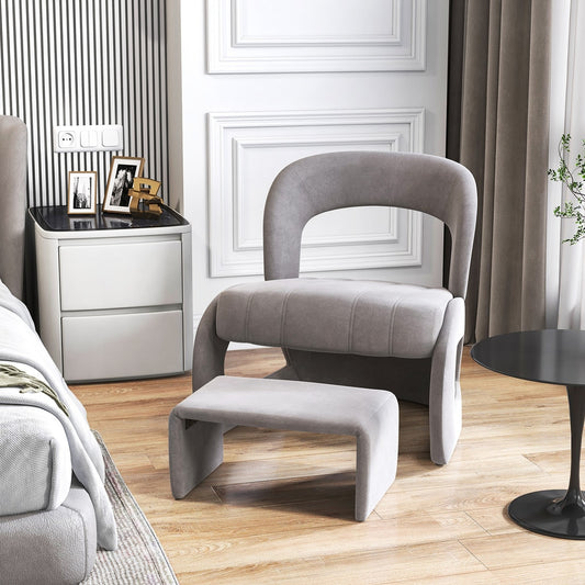 Grey accent chair and ottoman set in a modern bedroom setting next to a bed and bedside table