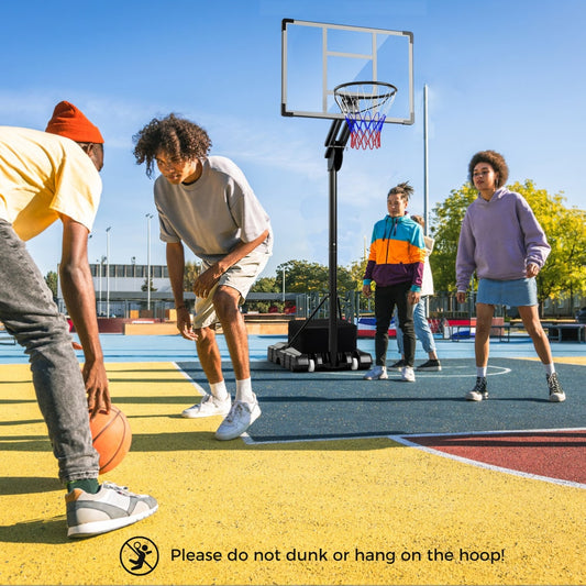 Young people playing basketball with the adjustable hoop on an outdoor court
