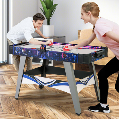 A man and woman playing a fast game on the air hockey table in a bright room