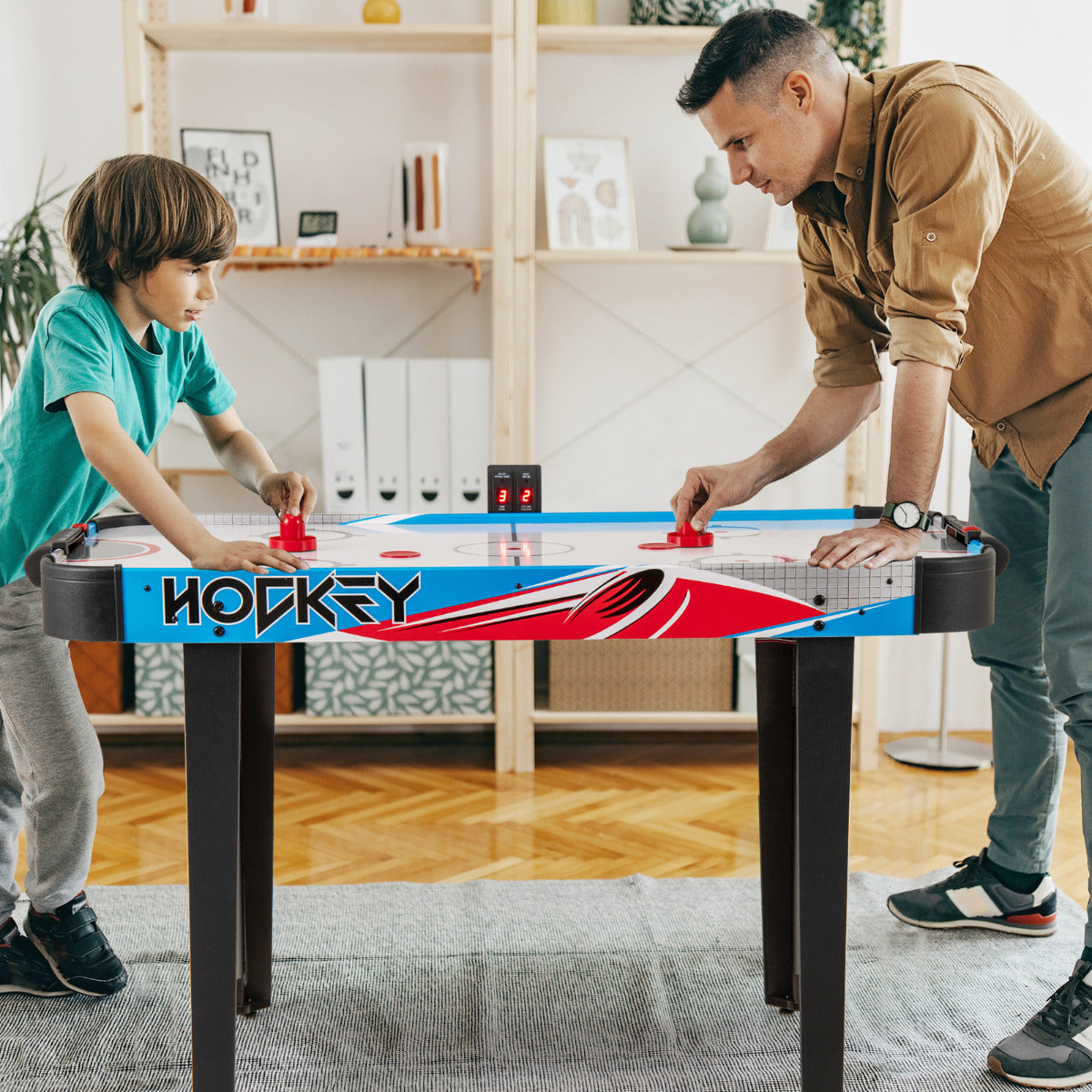 Father and son playing the game room air hockey table