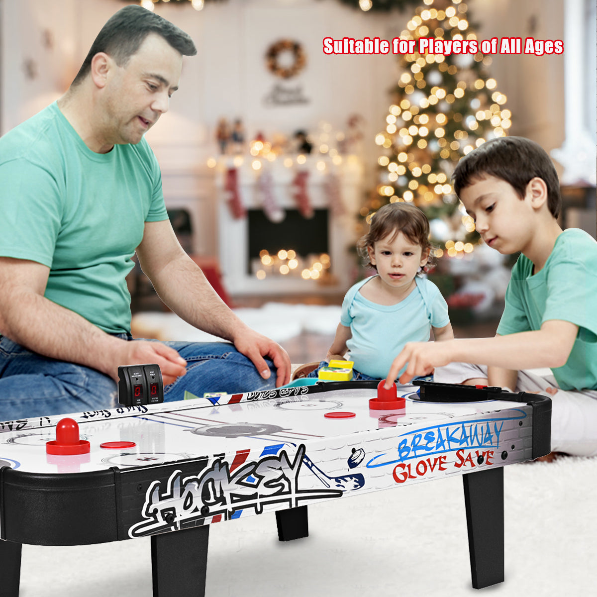Family playing the air powered hockey table in a room with a Christmas tree