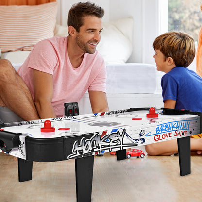 Father and son playing with the air powered hockey table in a living room setting