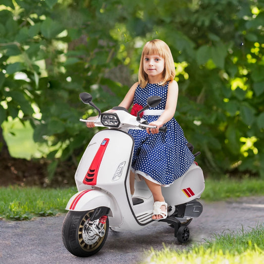 A young girl in a blue polka dot dress sitting on the white kids electric motorbike outdoors