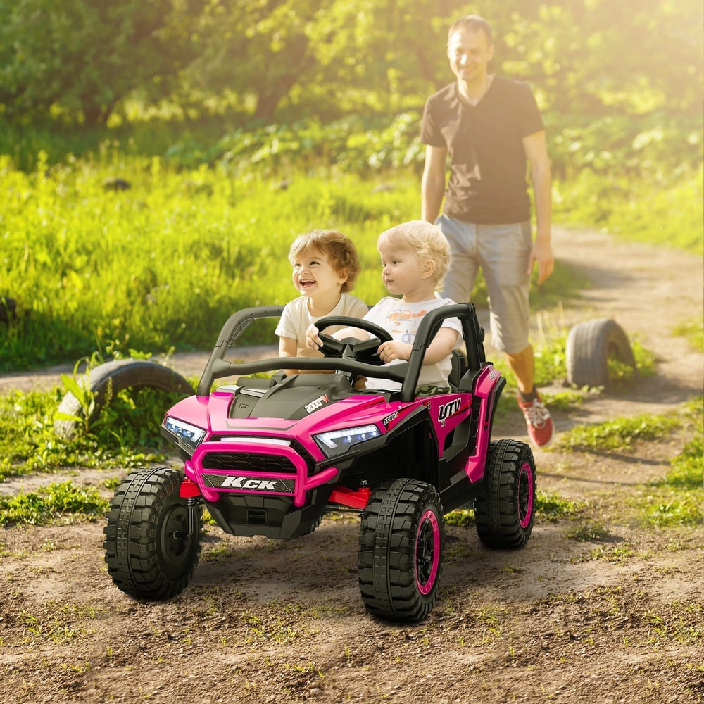 The kids electric car being driven by two children on a dirt path with an adult walking nearby
