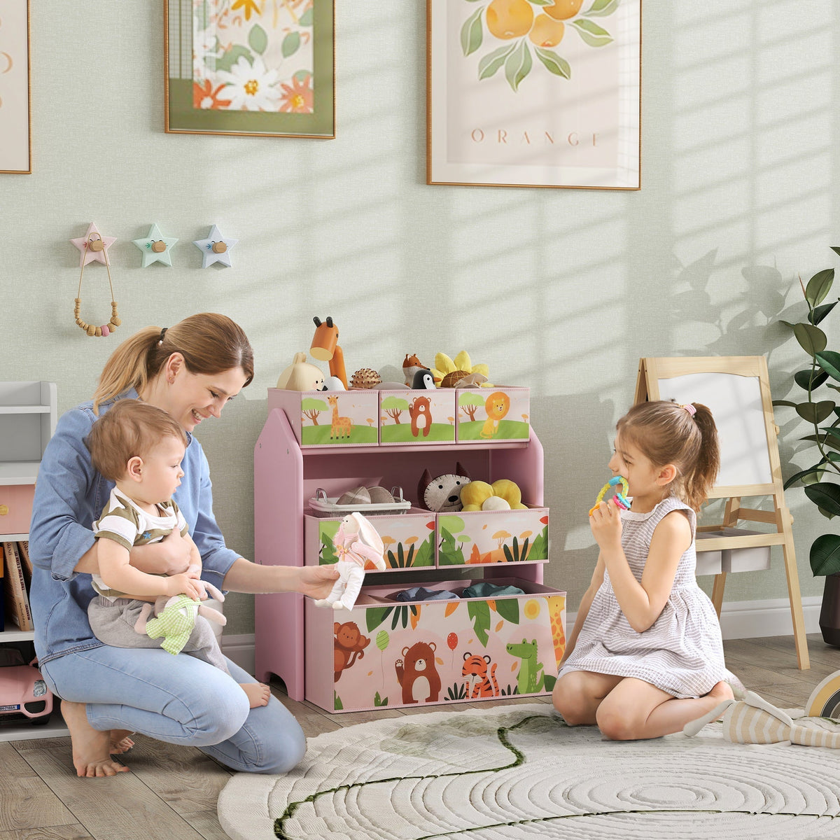 A mother and two children interacting with the pink toy storage unit in a nursery