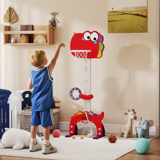A young boy plays with the dinosaur basketball hoop indoors