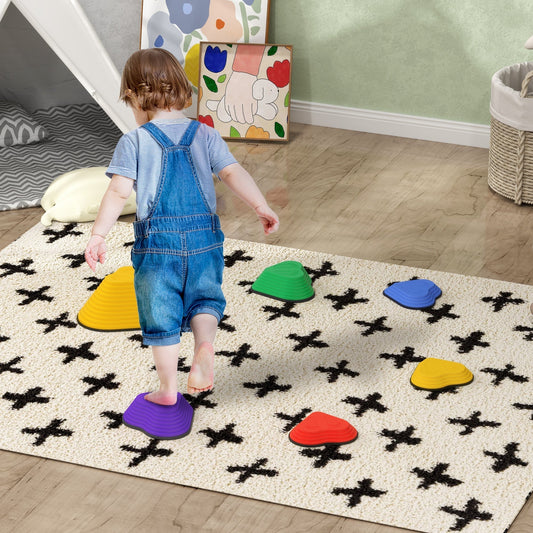 A toddler stepping on a purple heart-shaped balance stone on a rug