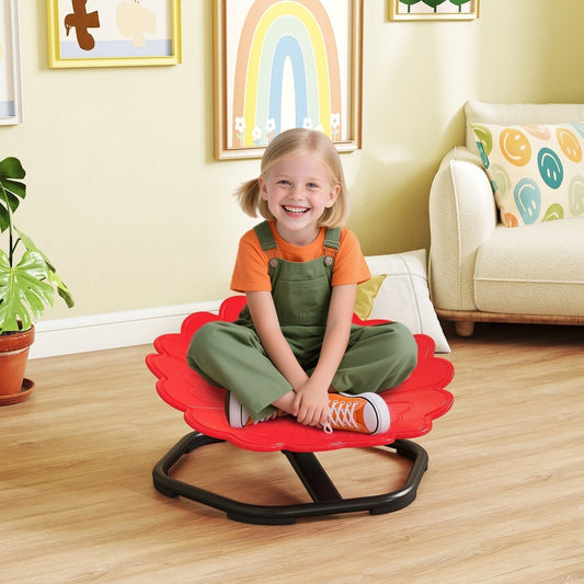 A happy young girl sits on the red flower-shaped spinning chair in a bright living room