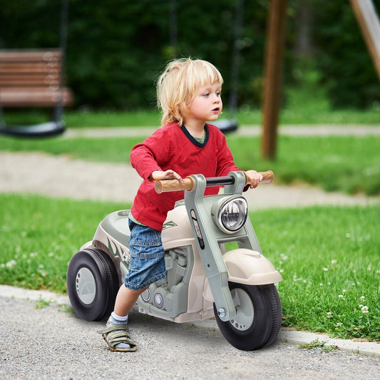 A young boy rides the cream white foot to floor sliding kids ride on car in a garden
