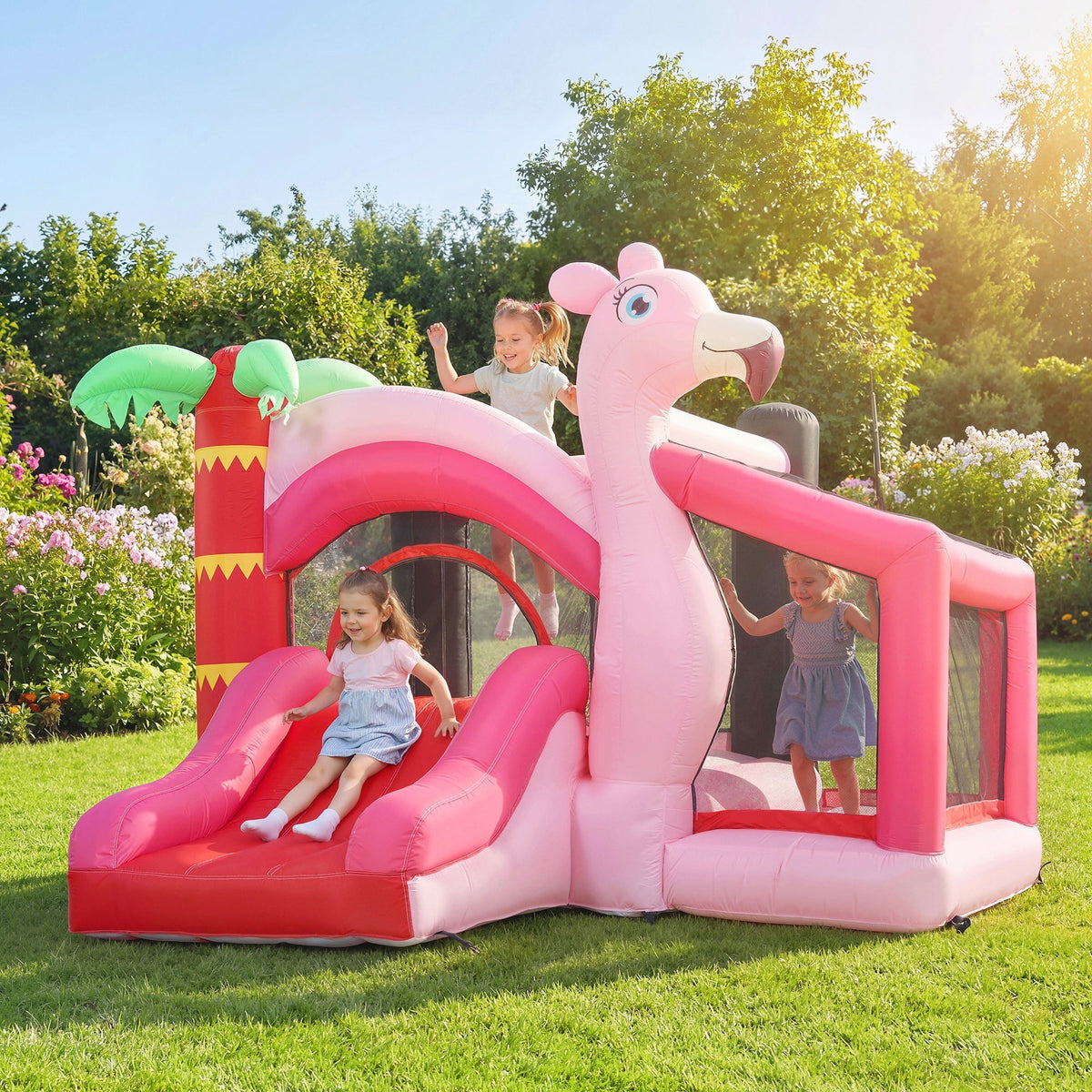 Children playing on the pink inflatable bounce house with slide in a sunny garden