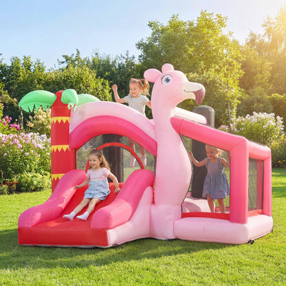 Children playing on the pink inflatable bounce house with slide in a sunny garden