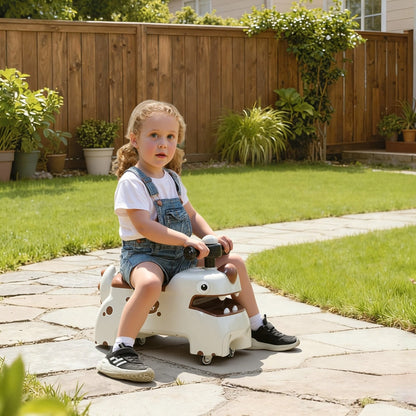 A young child sitting on the dinosaur ride on car on a stone path in a sunny garden
