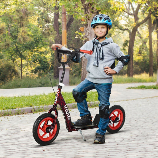 A young boy wearing protective gear rides the red kids kick scooter outdoors on a paved path