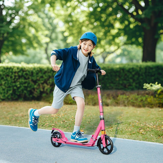 A young child rides the pink kids scooter outdoors on a paved path