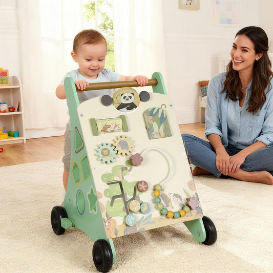 The baby walker being pushed by a toddler in a bright living room with a woman sitting nearby