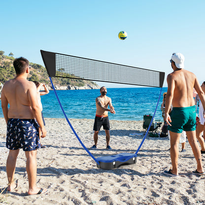 The portable badminton net set being used on a beach with adults playing volleyball