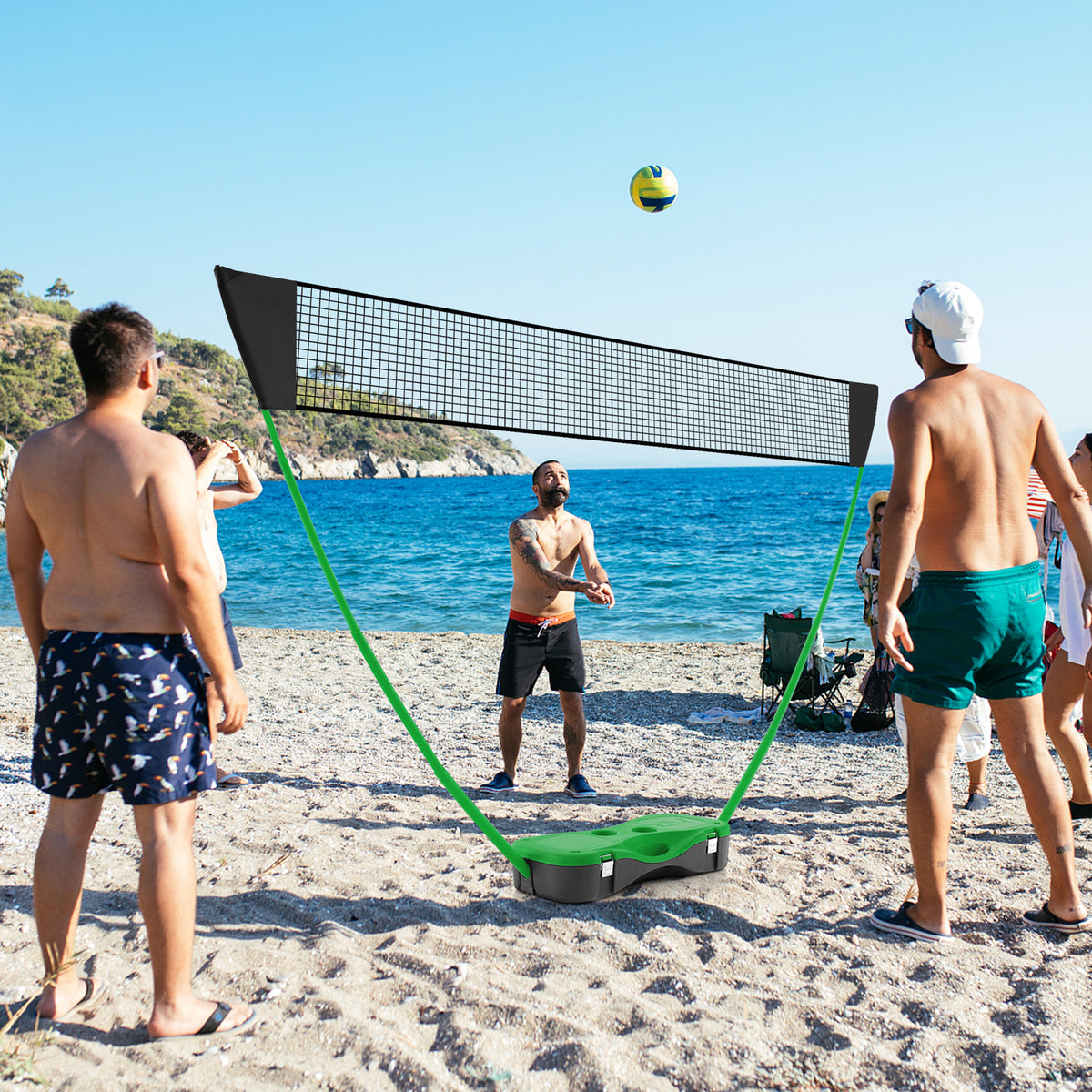 The badminton net set positioned on a sandy beach with a blue sea background