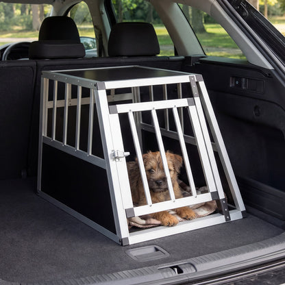 Aluminium dog transport box with a puppy inside in the boot of a car
