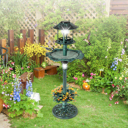 The green bird bath and feeder positioned on a lawn with a wooden fence