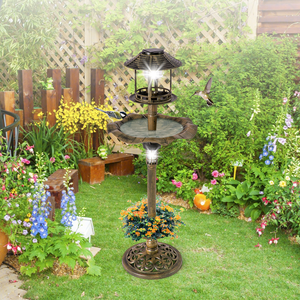 The antique lighted birdbath and feeder combo stands in a garden with a hummingbird and a bird