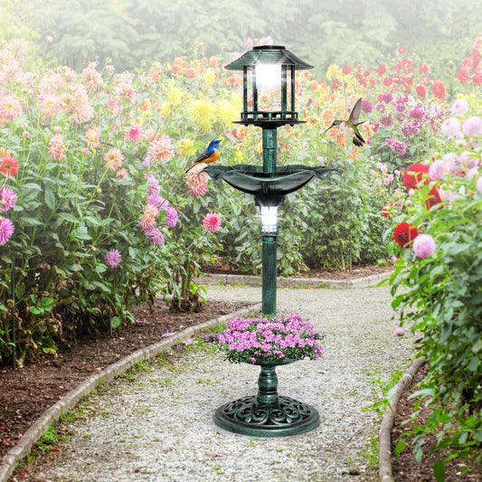 The green bird bath and feeder standing on a gravel path in a garden