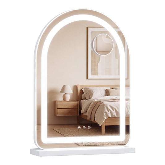 The vanity mirror standing on a wooden bedside table in a bedroom with the lights switched on