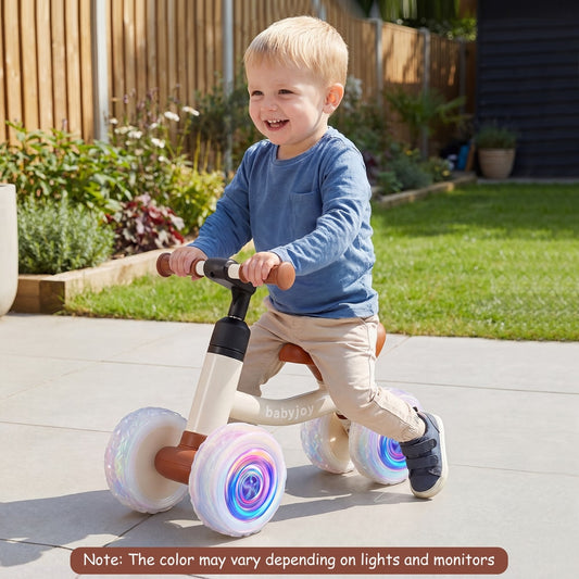 A toddler riding the balance bike on a patio with a garden in the background