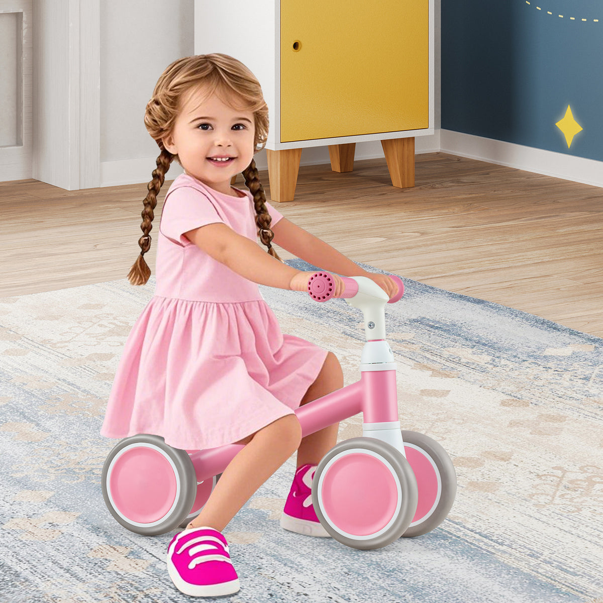 A happy toddler girl riding the pink balance bike indoors
