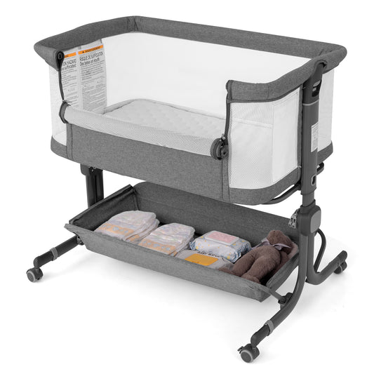 Baby Bassinet Bedside Sleeper in grey with a storage shelf containing nappies and a soft toy