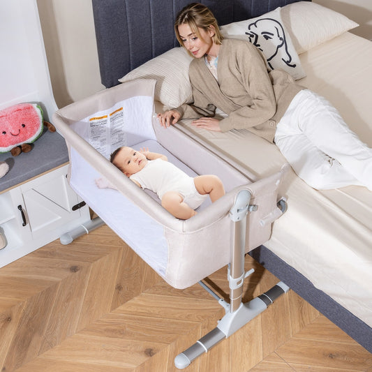 The bedside sleeper is next to a bed with a woman and a baby inside