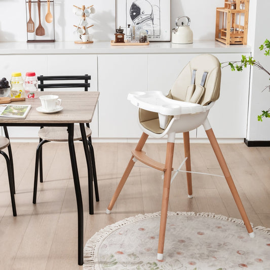 The beige high chair is set up in a modern kitchen next to a dining table