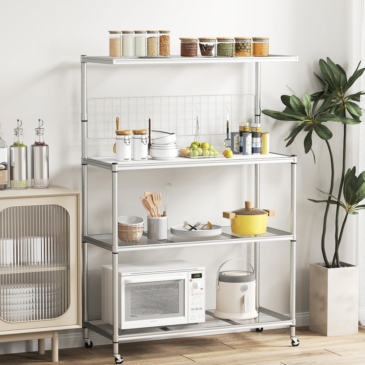 The silver bakers rack on wheels, fully assembled and holding kitchenware and food items