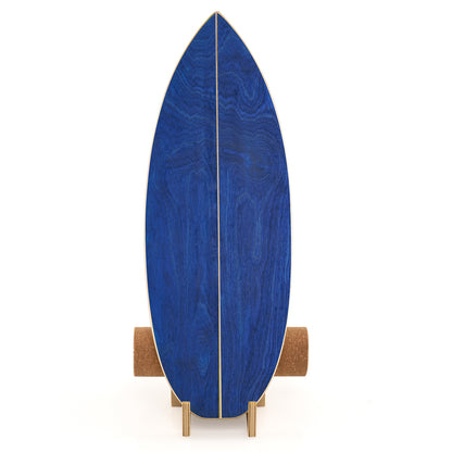 Blue wooden balance board standing upright on its wooden rack with cork roller