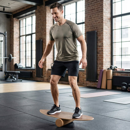 The sport equipment being used by a man standing on it to improve balance in a gym