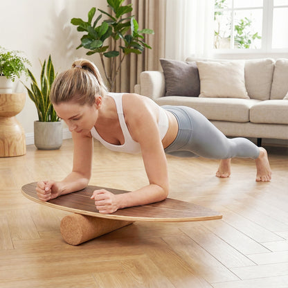The sport equipment being used by a woman performing a plank exercise in a living room